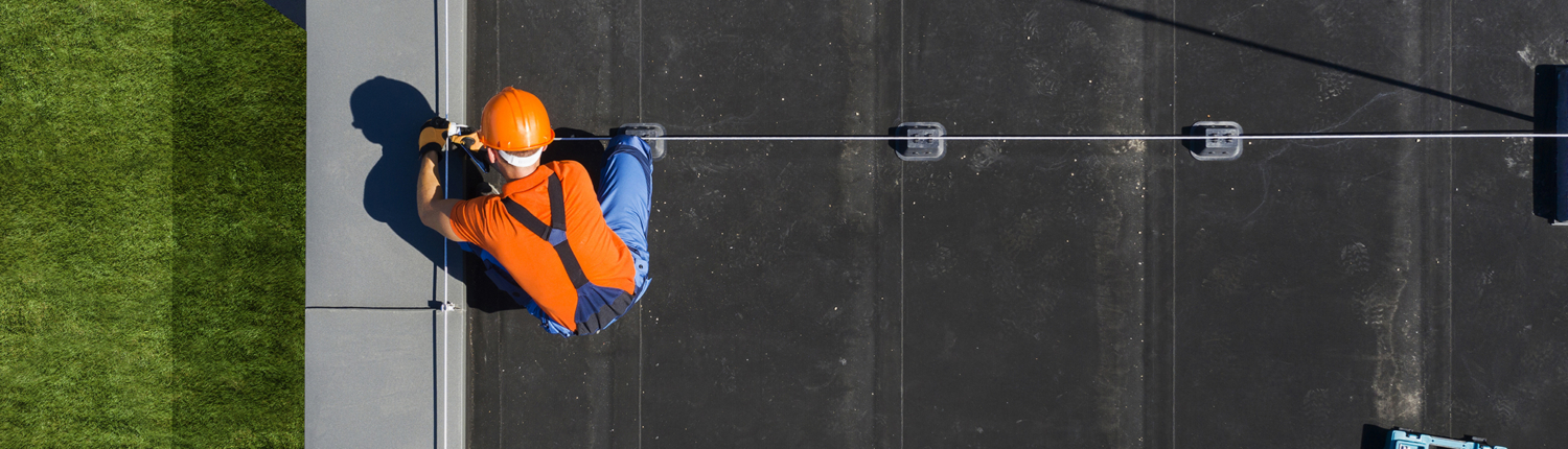 Man Installing Flat Roof on Commercial Building