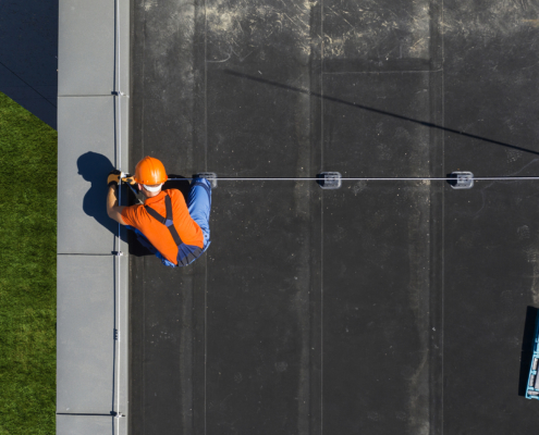 Man Installing Flat Roof on Commercial Building